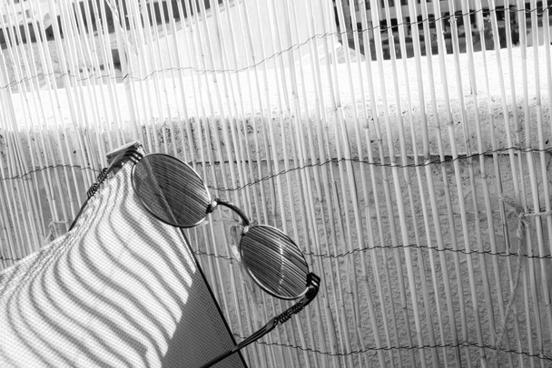 Sonnenbrillen im klassischen Design, die in der Sonne bleiben und darauf warten, getragen zu werden. Selektiver Fokus  - Foto, Bild