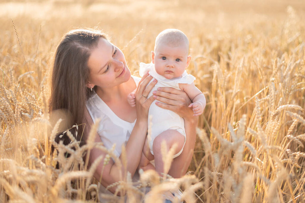 Güzel genç anne ve kızı buğday tarlasında güneşli bir günde Çek Cumhuriyeti 'nde - Fotoğraf, Görsel