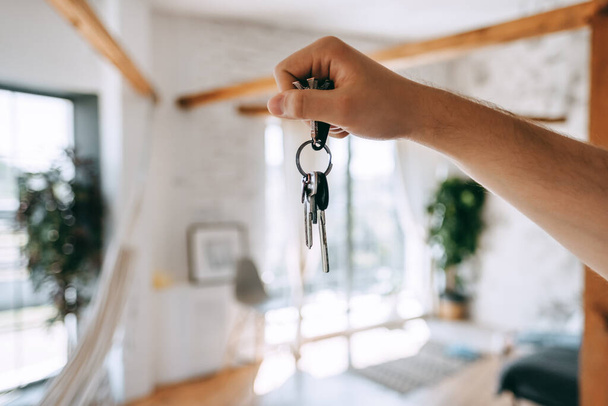 Man hand showing keys of new home, moving and buying new apartment concept. High quality photo - Photo, Image