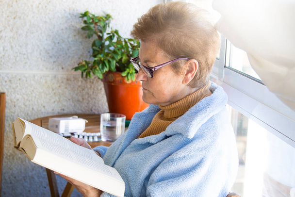 senior woman sitting reading a book - Fotoğraf, Görsel