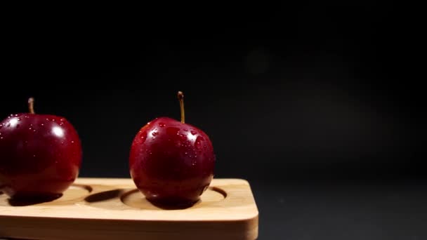 Tavola di legno con prugne mature dolci su sfondo scuro - Filmati, video