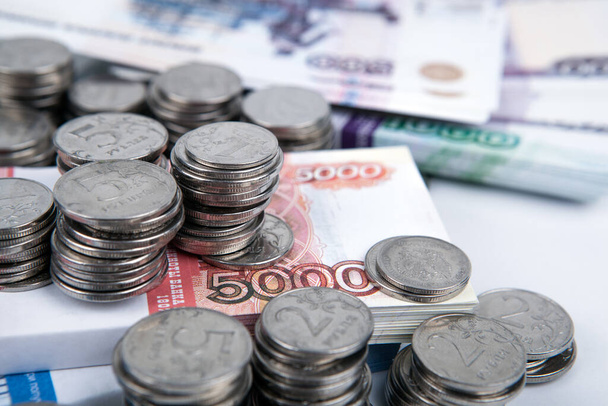 bundel Russische bankbiljetten en veel Russische munten close-up - Foto, afbeelding
