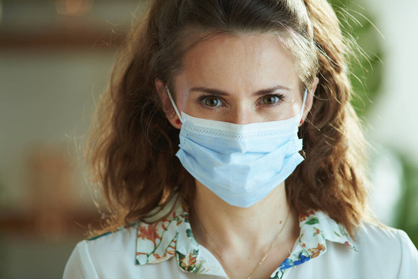 Life during coronavirus pandemic. Portrait of stylish female in white blouse with medical mask. - Фото, изображение