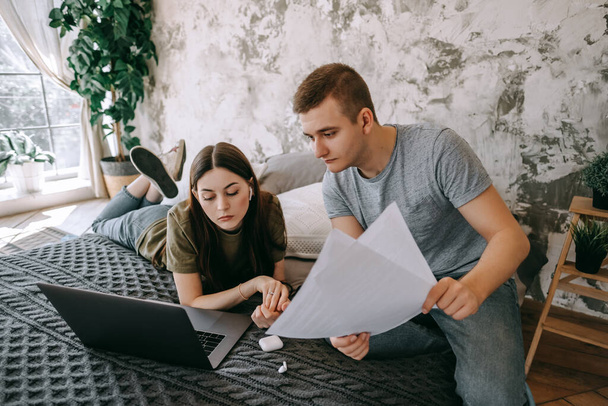 Coworkers discussing project and using laptop together, watching paper documents. Business colleagues together in cozy office space. Partnership or consulting concept. High quality photo - Fotó, kép