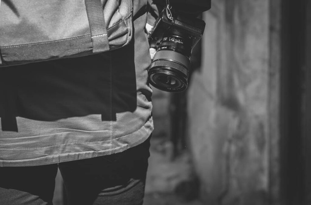 A Grayscale closeup shot of a photographer with a camera, view from the back - Photo, Image
