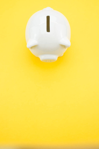 A closeup shot of a piggy bank on a yellow surface - investments and savings concept - Фото, зображення