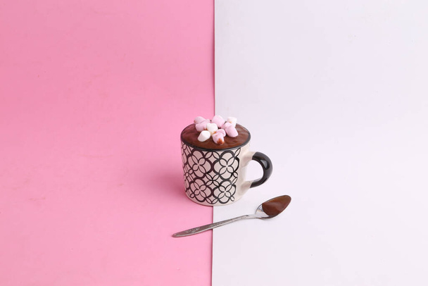 A cup of delicious homemade chocolate with marshmallows on a pink and white background - Fotografie, Obrázek