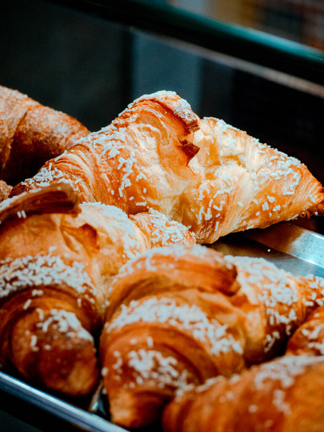A vertical shot of croissant bread displayed in the bakery - Fotoğraf, Görsel