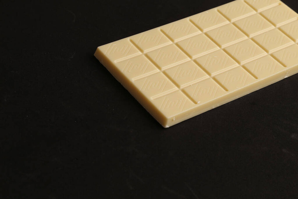 A milk chocolate bar isolated on black background - Foto, afbeelding