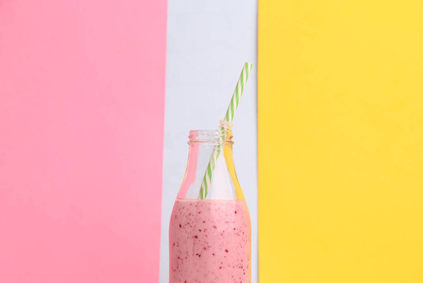 A closeup shot of raspberry smoothies in a bottle with straw - Fotografie, Obrázek