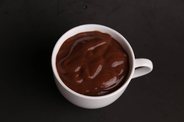 A high angle view of a cup of delicious hot chocolate isolated on a black background - Foto, immagini