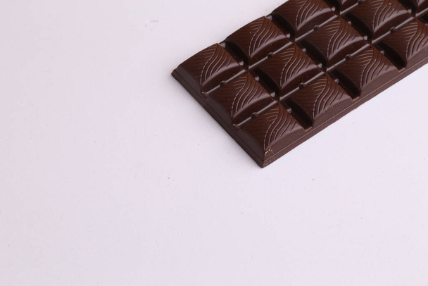 A high angle shot of a dark chocolate bar on a monochrome background - Foto, Bild
