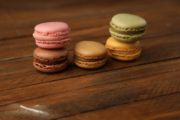 A closeup shot of delicious macarons on a wooden surface - Фото, изображение