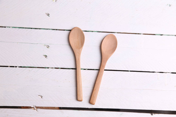 A top view of two wooden kitchen spoons on a white table - Foto, Imagen