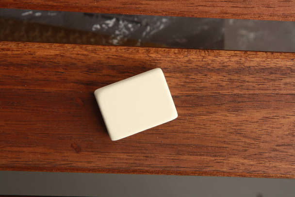 A closeup shot of a white eraser on wooden background - Photo, image