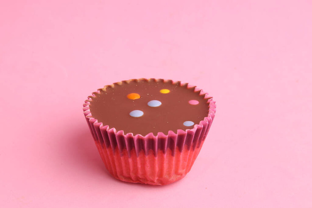 The sweet chocolate cupcake on the pink surface - Φωτογραφία, εικόνα