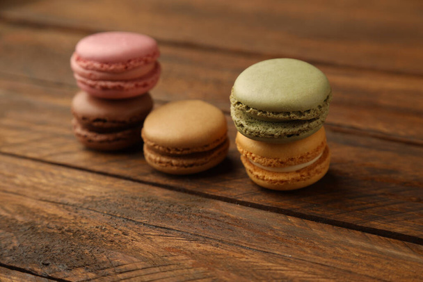 A closeup shot of tasty and colorful macarons on a wooden table - Fotografie, Obrázek
