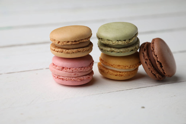 The sweet, delicious and colourful macaroon cookies  on the wooden surface - Фото, изображение