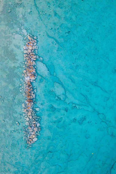 An aerial view of clear blue sea with rocks - Foto, Imagem