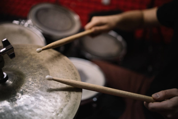 Male hands with drumsticks playing drum set - Foto, imagen