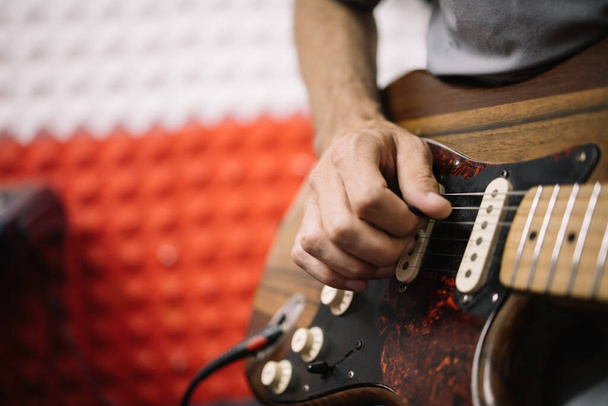 Close-up view of hands of male musician playing guitar - Foto, Imagen