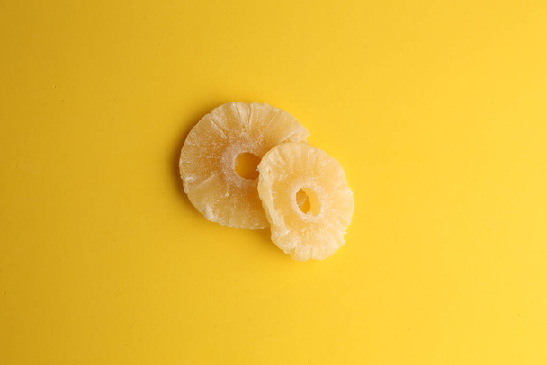 An overhead shot of two sliced dried pineapples isolated on a yellow background - Photo, Image