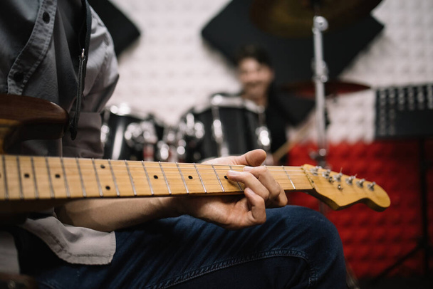 Cropped male musician playing guitar in studio - Fotoğraf, Görsel