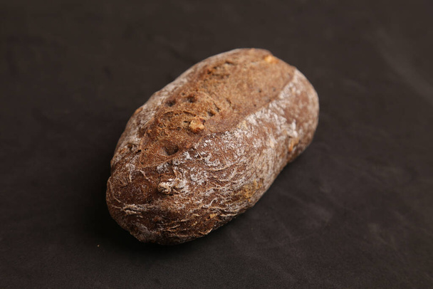 A high angle shot of homemade bread isolated on a black surface - Photo, image