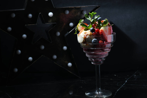 A closeup shot of a glass of chocolate dessert with different berries and fruits - Foto, afbeelding