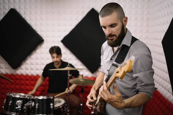 Band members playing electric guitar and drums - Φωτογραφία, εικόνα