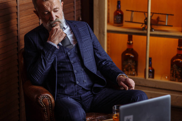 Senior dramatist looking at laptop, creating novel while sitting in pub. - Fotografie, Obrázek