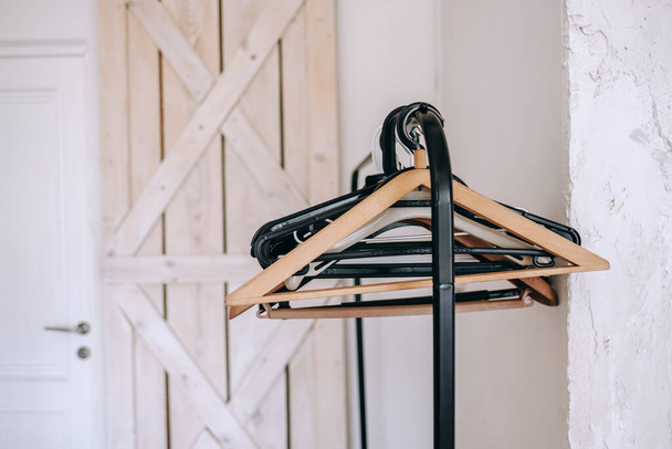 Black metal clothing rail with empty coat hangers in a white room. High quality photo - Foto, Imagen