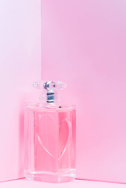 pink perfume bottle on pink background copy space. bot view, vertical orientation - Foto, Imagem