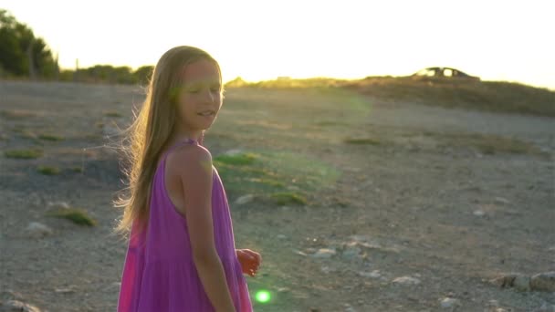 Malá dívka na vrcholu hory těší údolí pohled před západem slunce - Záběry, video