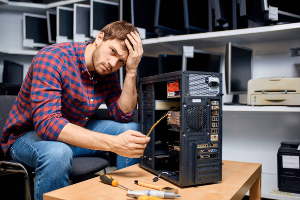 puzzled handsome man cannot solve the computer problem - Фото, изображение