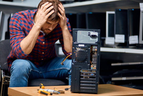 unhappy sad man with hands on his head has broken a computer - Photo, image