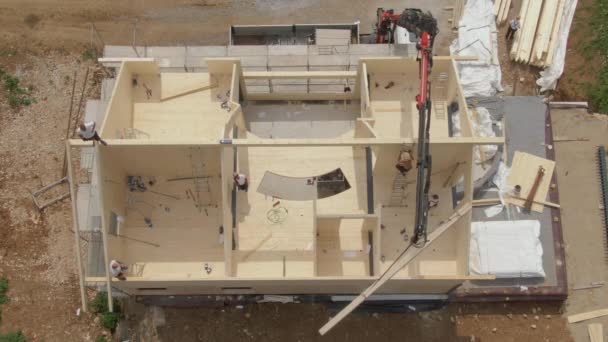 ARRIBA: Volando por encima de una moderna casa de madera laminada en cruz en construcción. - Metraje, vídeo