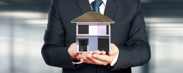 Dom model w ręku tam przestrzeń. dom, mieszkanie i koncepcja nieruchomości - Zdjęcie, obraz