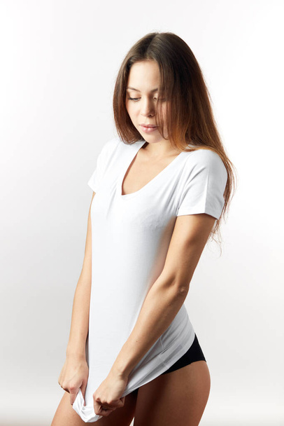 serious good looking pretty girl stretching her T-shirt - Фото, изображение