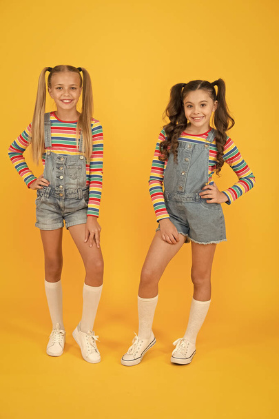 Hip and stylish. best friends forever. small sisters have fun. little girls yellow background. hairdresser salon. kid summer fashion. beauty and style. childhood happiness. happy school friendship - Foto, Bild