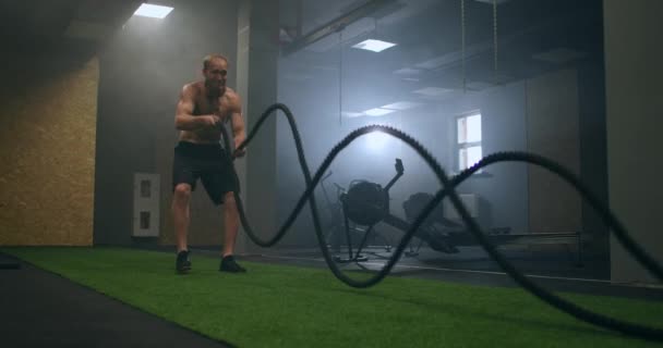 προπόνηση αθλητές φυσικής κατάστασης χρησιμοποιώντας σχοινιά μάχης έντονη άσκηση πρόκληση άσκηση στο γυμναστήριο απολαμβάνοντας υγιή τρόπο ζωής άσκηση αντοχής bodybuilding αργή κίνηση - Πλάνα, βίντεο