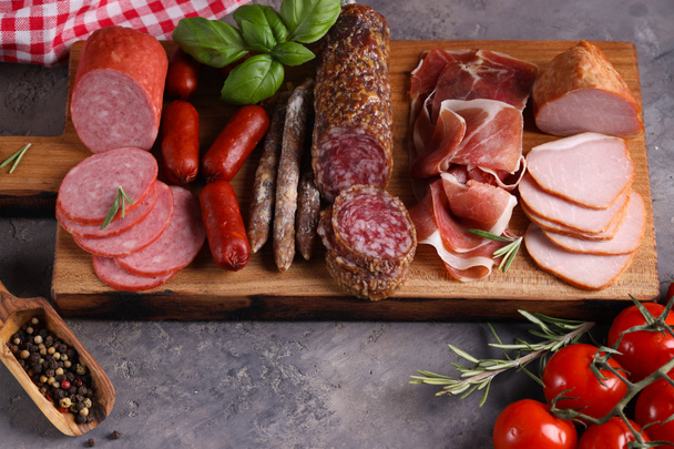 sausage and ham assortment on wooden board - Foto, Imagen