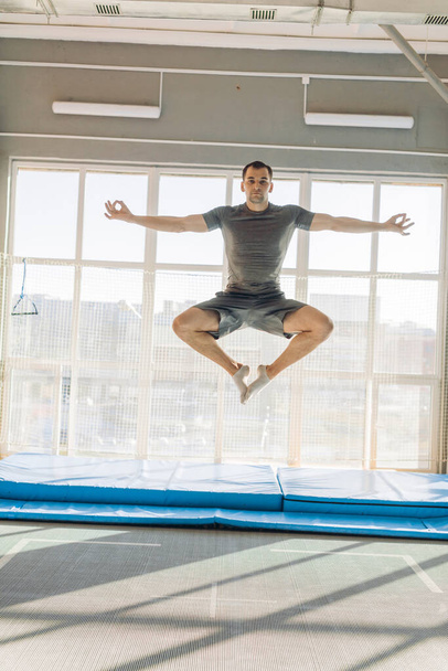 active fit man doing yoga while jumping. flying lotus position. flying yoga pose - Foto, immagini