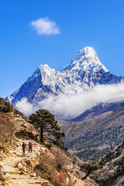 Tengboche, Nepál - November 3, 2018: Az emberek túráznak a túra Everest Base Camp Tengboche, fenséges Ama Dablam csúcs a háttérben. - Fotó, kép