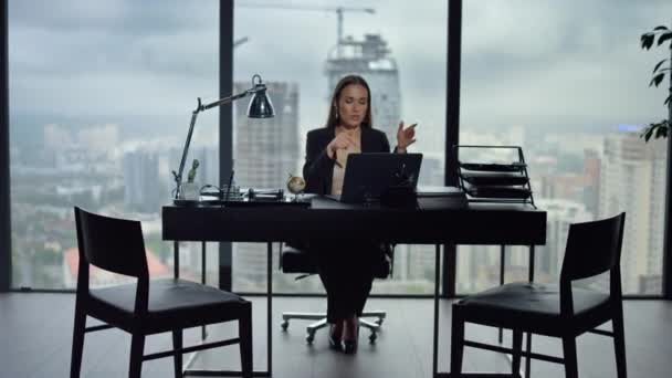 Unternehmerin im Videochat am Arbeitsplatz auf dem Laptop. Frau gestikuliert in Kamera - Filmmaterial, Video