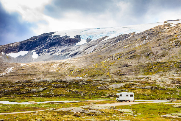 Camper car in norwegian mountains. Camping on nature. Traveling, holidays and adventure concept. - Photo, Image