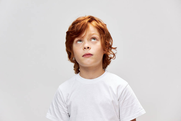 Red-haired boy looking up white t-shirt cropped  - Foto, Bild