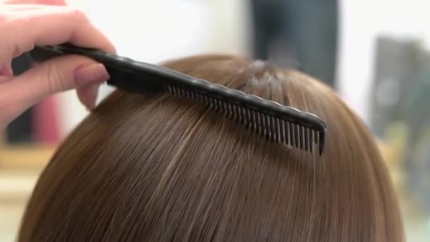 ruka s hřebenem kartáčování vlasy ženské vlasy zblízka - Záběry, video