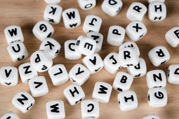 Textová kostka koncept kostky / Písmeno kostky abeceda na dřevěném pozadí. Blok abecedy posázený na podlaze. - Fotografie, Obrázek