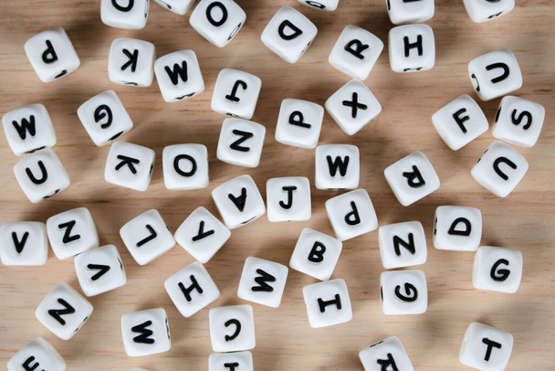 文字ダイスキューブのコンセプト/文字は木製の背景にアルファベットをダイシングします。床にちりばめられたアルファベットのブロック. - 写真・画像
